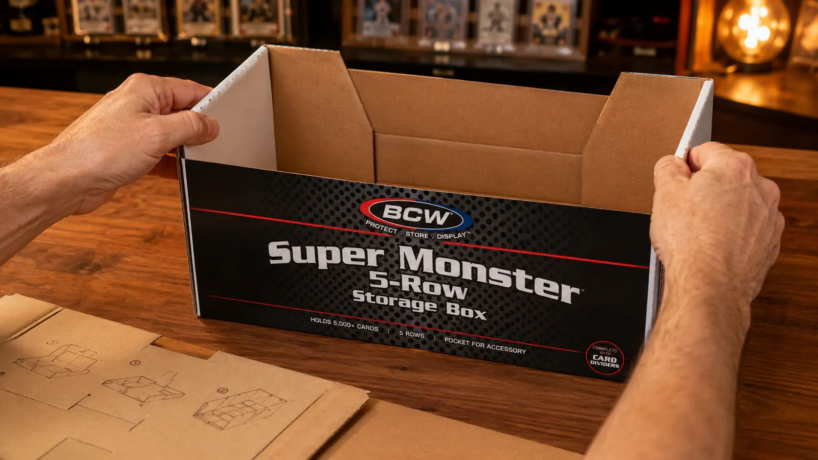 Hands assembling a flat-packed BCW Super Monster box, folding the side walls up from a flat cardboard blank