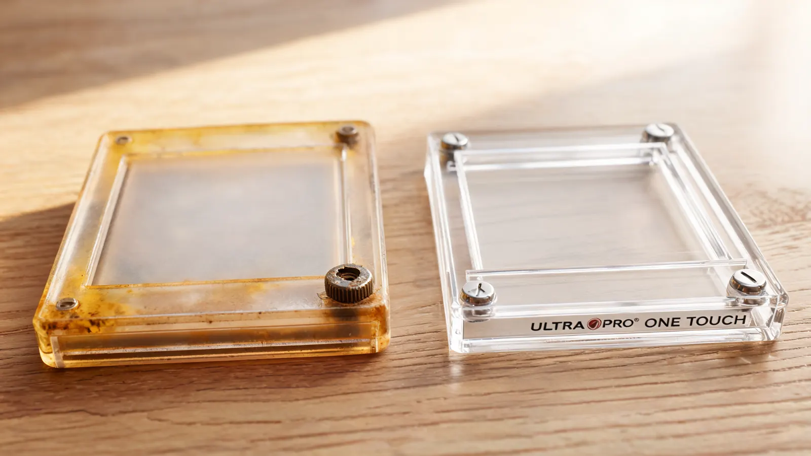 Close-up of a yellowed screw down card case with stripped corner screw next to an intact Ultra Pro One Touch showing contrast in long-term condition