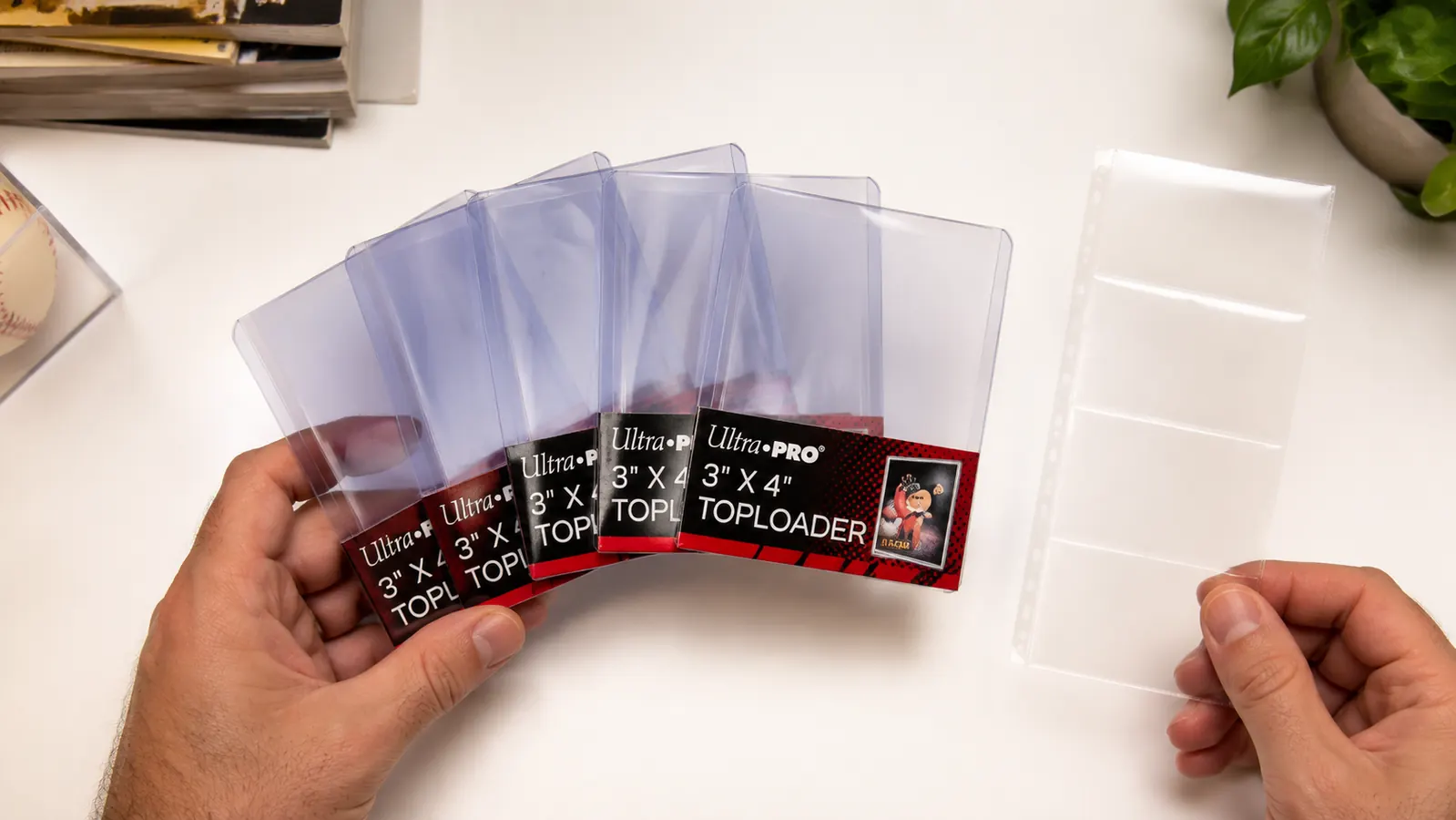 Ultra Pro 3x4 top loaders fanned out next to a strip of penny sleeves on a flat surface