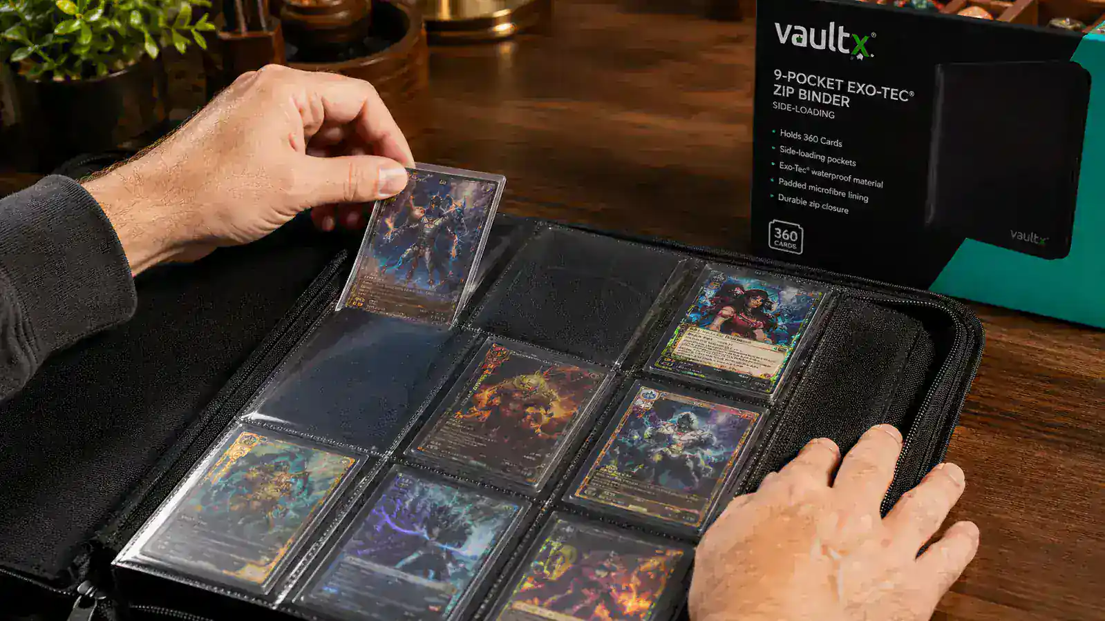 Close-up of a collector's hand sliding a sleeved Pokemon card into a Vault X side-loading binder page